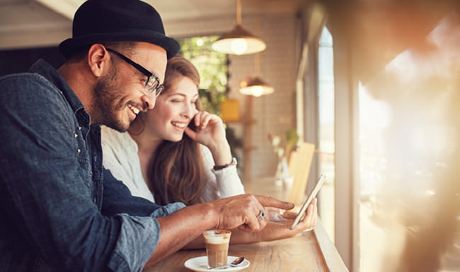 Luxury Living residents look at a cell phone together at local cafe